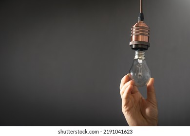 Man Changing Light Bulb At Home.