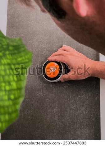 Man Changing Temperature using Digital Home Thermostat