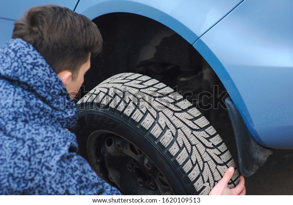 Man is changing
tire with wheel on the car