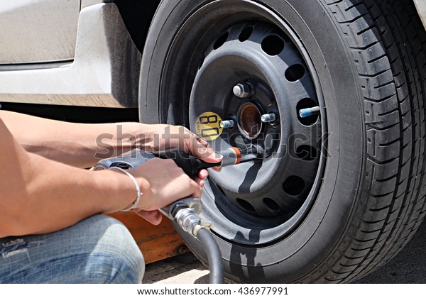 Man is changing tire with wheel wrench. Auto\
mechanic changing car wheel \
