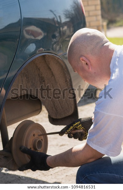 Man changing wheel after a car breakdown.\
Transportation, traveling\
concept