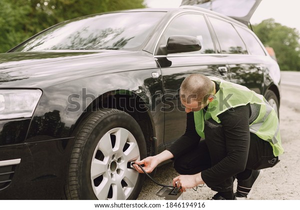 Man changing wheel after a car breakdown.\
Transportation, traveling\
concept.