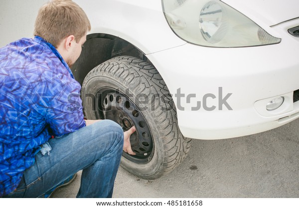 man changing a wheel on the road. on way there
was breakage of wheel, puncture, necessary to lift the car jack and
remove the wheel by loosening the nuts. road problems travelers. do
it yourself