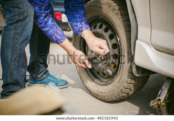 man changing a wheel on the road. on way there
was breakage of wheel, puncture, necessary to lift the car jack and
remove the wheel by loosening the nuts. road problems travelers. do
it yourself