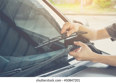 Man is changing windscreen wipers on a car ,picture vintage style