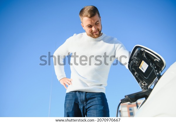 Man
charges an electric car at the charging
station