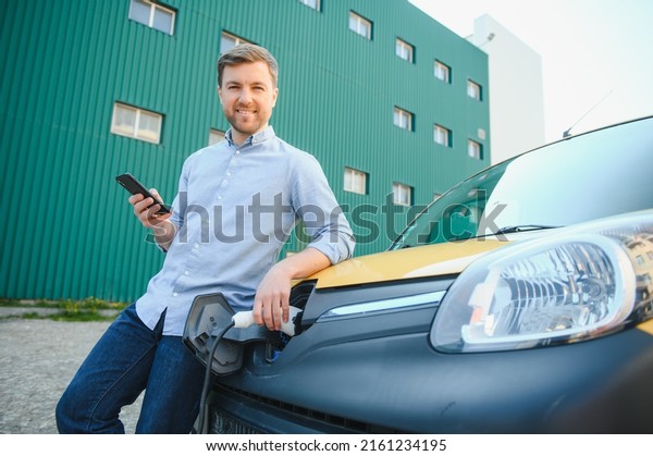 Man
charges an electric car at the charging
station