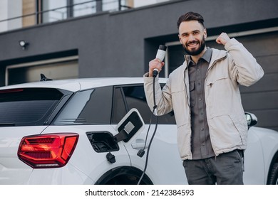 Man Charging Electric Car By The House