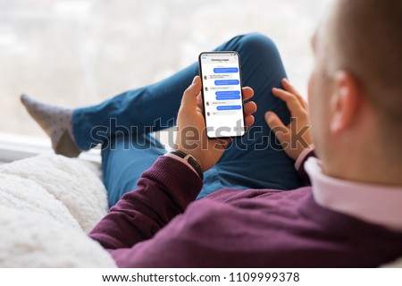 Man chatting with friends on mobile phone.