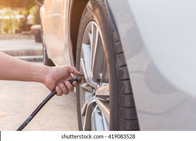 Man Checking Air Pressure And Filling Air In The Tires Of His Car