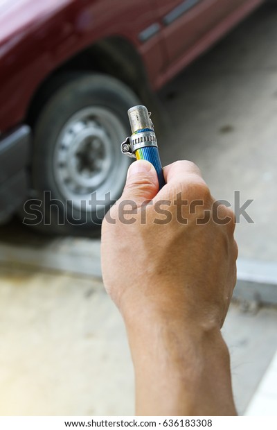 A man checking air pressure and filling air in the\
tires of car