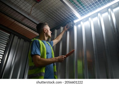 Man Checking Alarm In Warehouse Garage