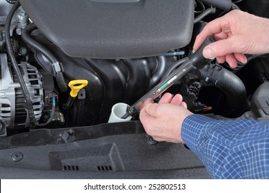 Man Checking Antifreeze In A Car Coolant System