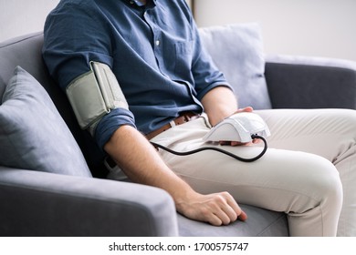 Man Checking Blood Pressure At Home. Chronic Disease