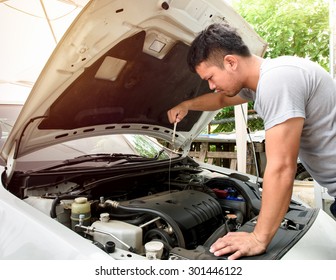 A Man Checking Car Engine At Home