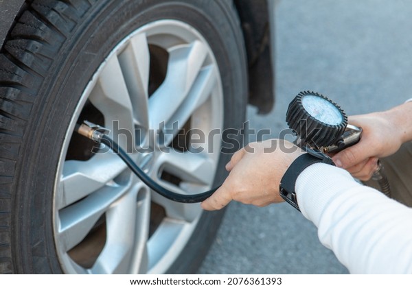 man\
checking car tire pressure car travel road\
trip