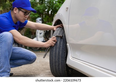 A man checking and fixing a broken car on the side of the road. Problems with broken cars on the highway Man looking under the hood of a roadside assistance concept car. - Shutterstock ID 2206109673
