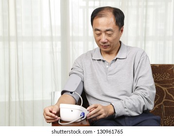 Man Checking His Blood Pressure At Home