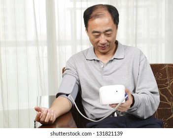 Man Checking His Blood Pressure At Home