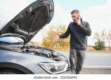 Man checking his broke down car.
