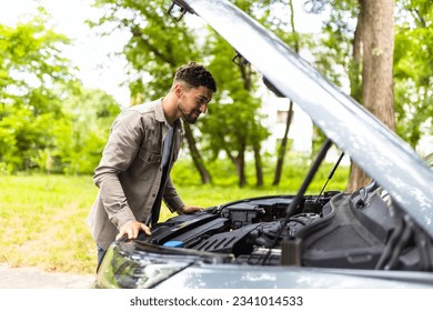 Man checking his broke down car.
