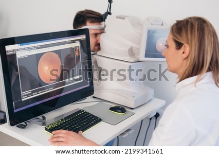 man checking his eye sight on retina scanner in clinic