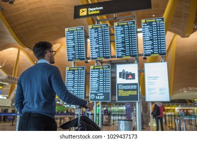 Man Checking His Flight On The Timetable Display At The Airport