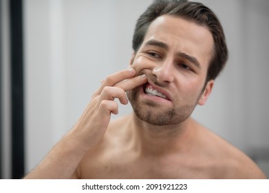 Man Checking His Teeth And Looking Disturbed