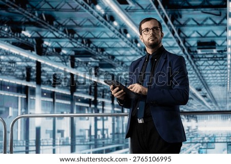 Man checking infrastructure malfunctions in industry 4.0 manufacturing plant with tablet. Management executive assessing modern smart factory semiconductor yields using device
