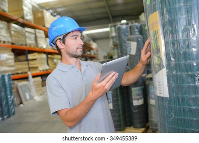 Man Checking Label On Roll Of Fencing