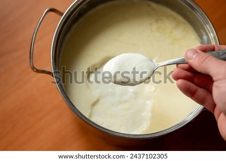 Man checking out self made yogurt. Making yogurt by yourself at home, tasty useful dairy product