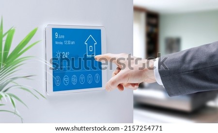 Man checking a smart home touch screen control panel, home automation concept