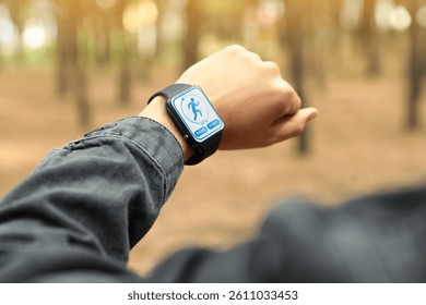 Man checking smart watch with step counting app outdoors, closeup