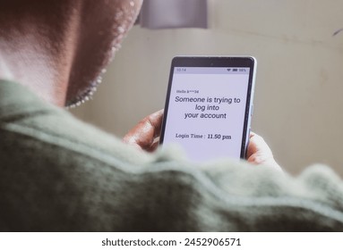 Man checking smartphone message saying someone trying to log into your account. Screen hacking, phishing concept.
