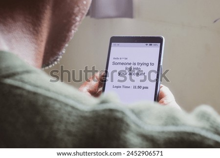 Man checking smartphone message saying someone trying to log into your account. Screen hacking, phishing concept.