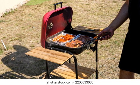 Man Checking State Of Grilled Meat On Aluminum Tray