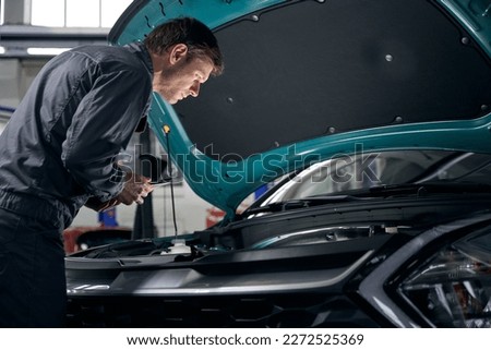 Man checking technical condition of car engine