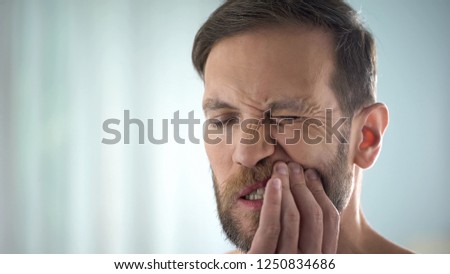 Man checking teeth in front of mirror, dental disease, gum infection, pulpitis
