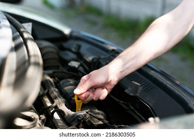 Man Checking Th Engine Oil Level  At The Parking. Regular Car Service.