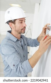 A Man Checking The Thermostat