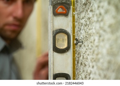 The Man Checks The Attached Guide Beacon For Equality With The Help Of A Level, Checks The Construction Level, Construction And Repair Work.