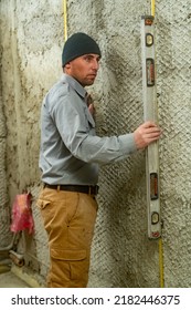 The Man Checks The Attached Guide Beacon For Equality With The Help Of A Level, Checks The Construction Level, Construction And Repair Work.