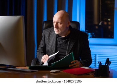 A Man Checks Documents. Businessman Working At The Computer. A Man Makes Reconciliation Of Data. Businessman In A Suit.