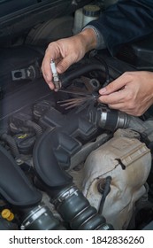 A Man Checks The Spark Gap In The Spark Plug With A Probe, Close-up Vertical Photo