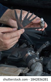 A Man Checks The Spark Gap In The Spark Plug With A Probe, Close-up Vertical Photo