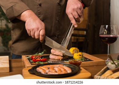 Man Chef Coocking Dishes On A Wooden Table In Restaurant