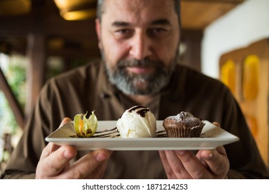 Man Chef Coocking Dishes On A Wooden Table In Restaurant