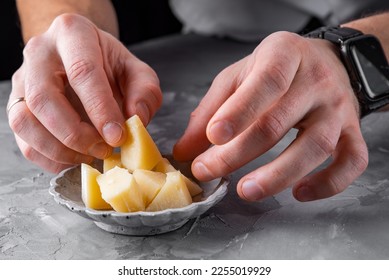 man chef hand takes parmesan cheese cubes on plate - Shutterstock ID 2255019929