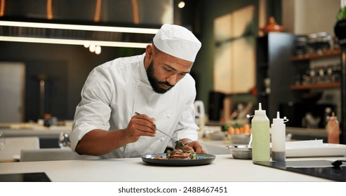 Man, chef and serious with food in kitchen at restaurant for fine dining, meal and creativity. Male employee, professional and cooker with pride for culinarily, hospitality and catering service