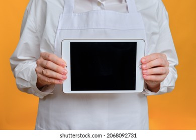 Man Chef Showing Tablet Ipad Screen On Yellow Studio Background, Mockup Copy Space - Moscow, Russia, October 20, 2021